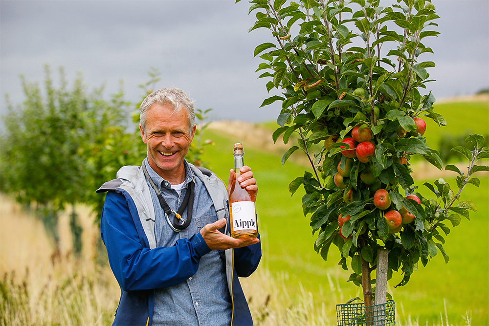 Roger Howison holding a bottle of his farm made cider.